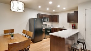 A modern kitchen with wooden cabinets, a black refrigerator, a microwave, and a coffee maker. - 6B Cozy Moab Redcliff Condo, Pet Friendly, Pool & Hot Tub (Moab)