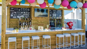 Zona de bar con paredes de madera, un televisor de pantalla plana y una variedad de botellas.