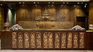 En reception med detaljerede udskæringer, en niveaudelt struktur og blomsterdekorationer.