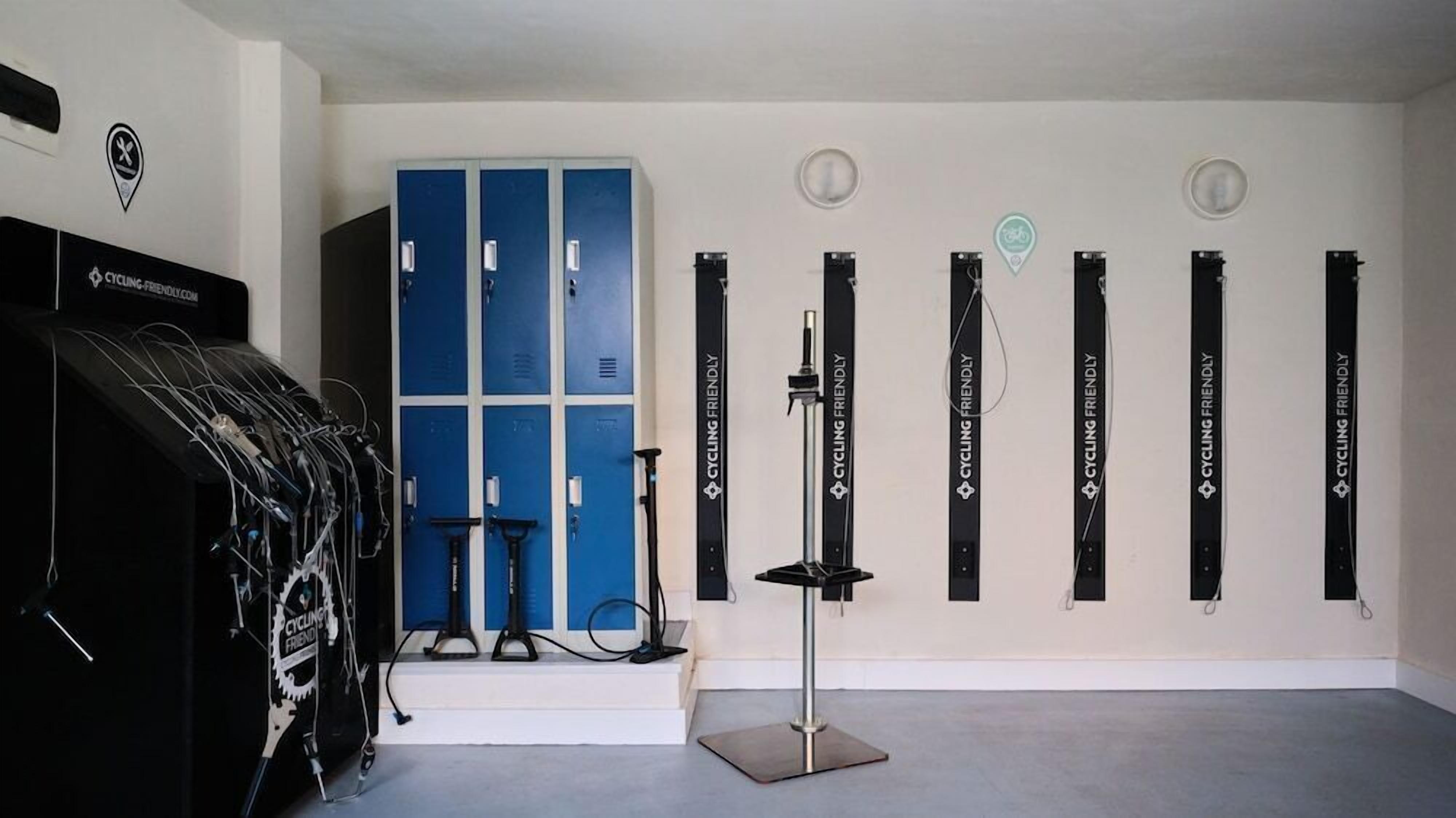 A room with a cycling-themed decor, including a wall-mounted bike rack and a blue locker area.