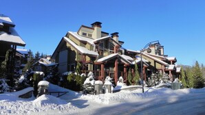 A large, multi-story lodge with a prominent ski lift, surrounded by snow-covered trees and a clear blue sky. - FAB FITZWALK Townhome FAMILY GETAWAY! Hot Tub, 2 car garage, minutes to Village (Whistler)