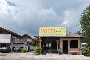 Un pequeño edificio de ladrillo con un letrero que dice “HOTEL” y una dirección web.