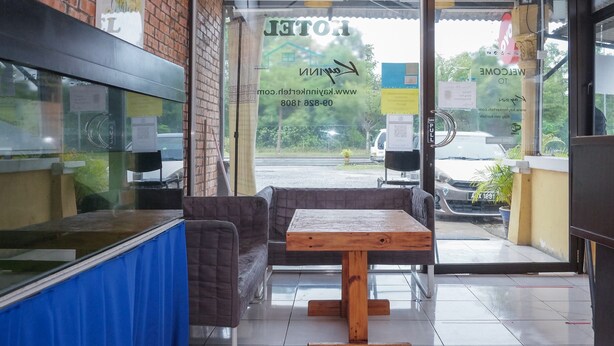 A restaurant with a glass door, a wooden table, and a cushioned bench. - Hotel O Kay Inn Kerteh (Kerteh)