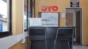 A reception area with a sign for 'Kay Inn' and a 'Staff Only' sign. There are two chairs in front of the reception desk.