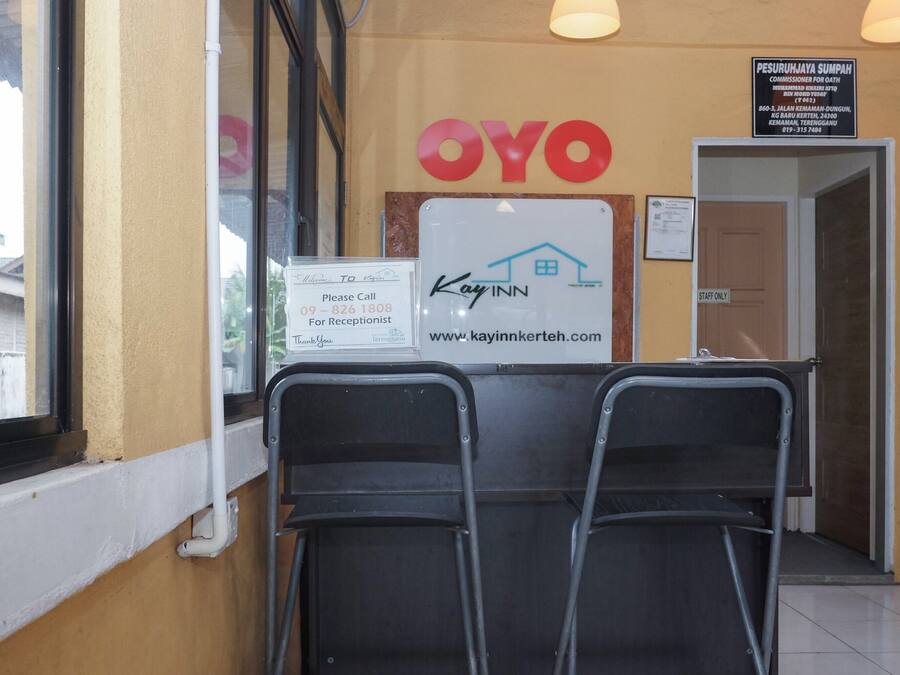A reception area with a sign for 'Kay Inn' and a 'Staff Only' sign. There are two chairs in front of the reception desk.