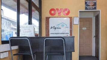 A reception desk with a sign for Kayinn Kerteh, a reception area, and a door marked "STAFF ONLY".