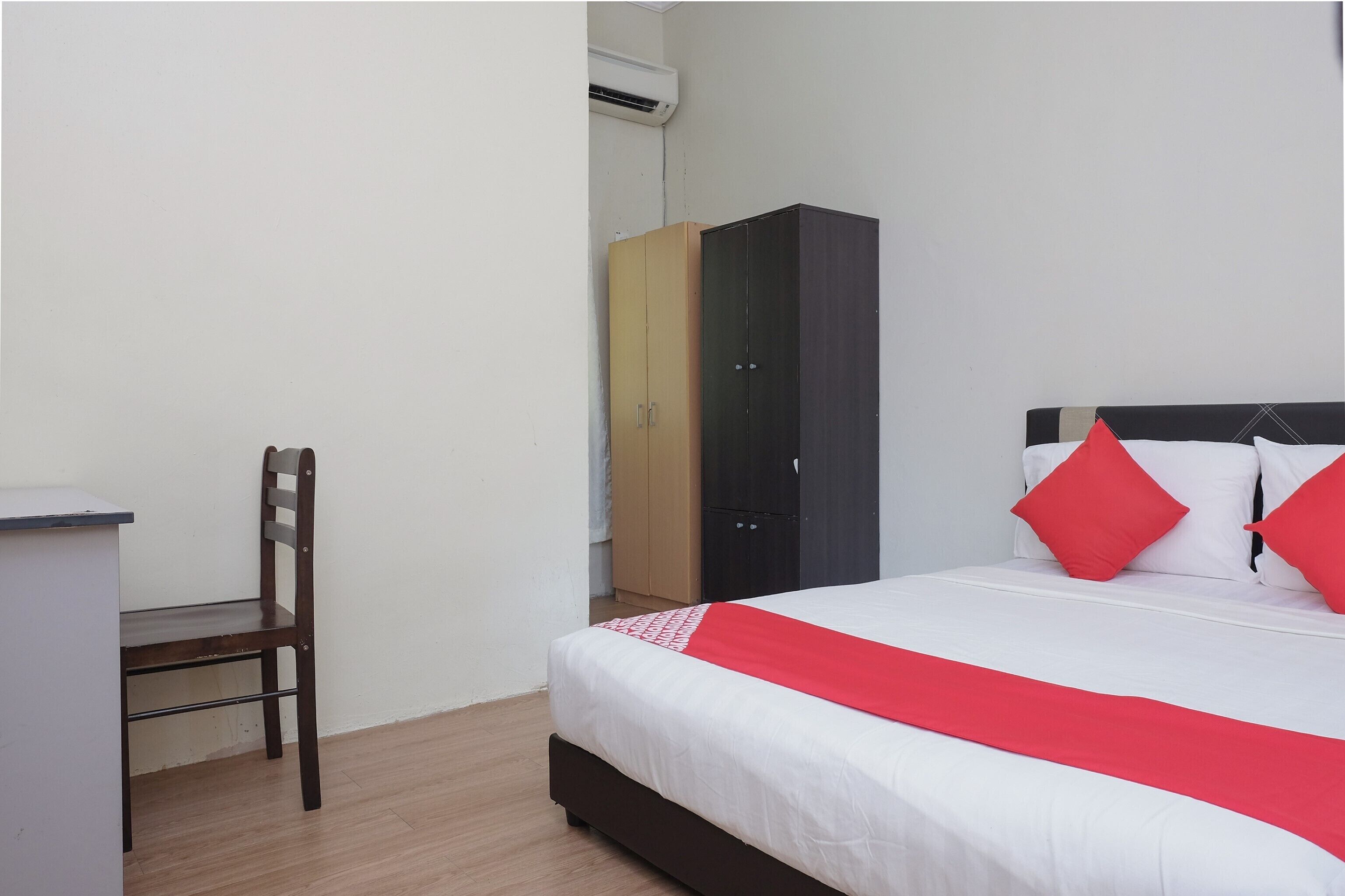 A bedroom with a bed, a desk, and a chair.