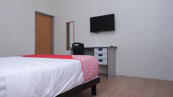 A bedroom with a bed, a desk, a chair, a television, and a mirror.