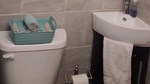 Een badkamer met toilet, wastafel en spiegel.