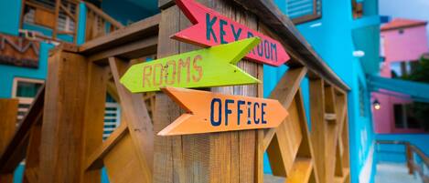 A wooden signpost with directional arrows pointing to 'Key Room', 'Rooms', and 'Office'.