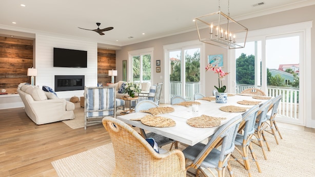A spacious living room with a fireplace, a dining area with a large table and chairs, and a balcony with a view. - CLOSE TO CHARLESTON/ROOFTOP/LUXURY AMENTIES/POOL/OCEAN VIEW/FANTASTIC FALL RATES (Isle of Palms)