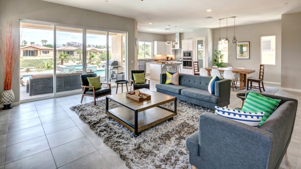 A spacious living room with a large sofa, a coffee table, and a view of the backyard. - Brand New Desert Princess Villa with Private Pool, Spa and View (Cathedral City)