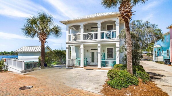A two-story house with a balcony, a porch, and a view of the water. - Wave Whisperer  4br/4ba Steps from the Beach - Pool (Santa Rosa Beach)