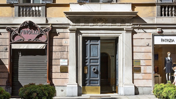 A building with a large entrance, a sign reading "Finollo," and a storefront named "Patrizia." - Boutique Apartment in Via Roma by Wonderful Italy (Genova)
