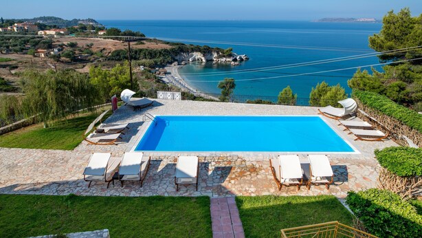 A swimming pool with lounge chairs and a view of the sea. - Private Villas with Shared pool#1 (Argostoli)