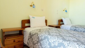 A hotel room with two beds, wooden nightstands, and wall-mounted lamps. - Private Villas with Shared pool#1 (Argostoli)