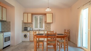 A compact kitchen with a dining area, a washing machine, and a microwave. - Private Villas with Shared pool#1 (Argostoli)