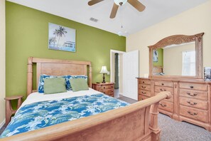 A bedroom with a wooden bed, a nightstand, a dresser, and a ceiling fan. - South-Facing Pool & Spa • Golf Course View • Near Disney • Golf (Davenport)