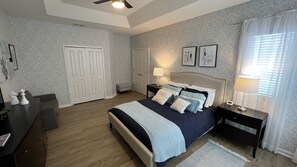 Ein Schlafzimmer mit Bett, Nachttischen, Schreibtisch und Kleiderschrank.