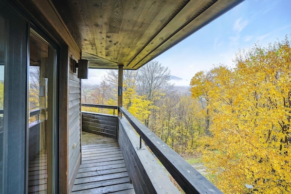 A wooden balcony with a view of autumn foliage. - 2-bedroom plus loft condo with mountain views, pool, and hot tub. (Killington)