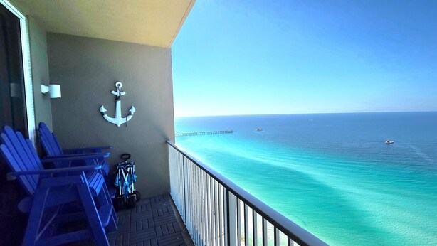 A balcony with a view of the ocean, a white anchor decoration, and blue chairs. - Gulf Front PH •Free Chairs• Best Views in PCB (Panama City Beach)