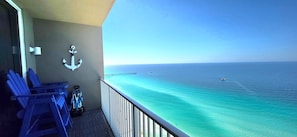 A balcony with a view of the ocean, a white anchor decoration, and blue chairs. - Gulf Front Penthouse •Free Chairs• Best Views PCB (Panama City Beach)