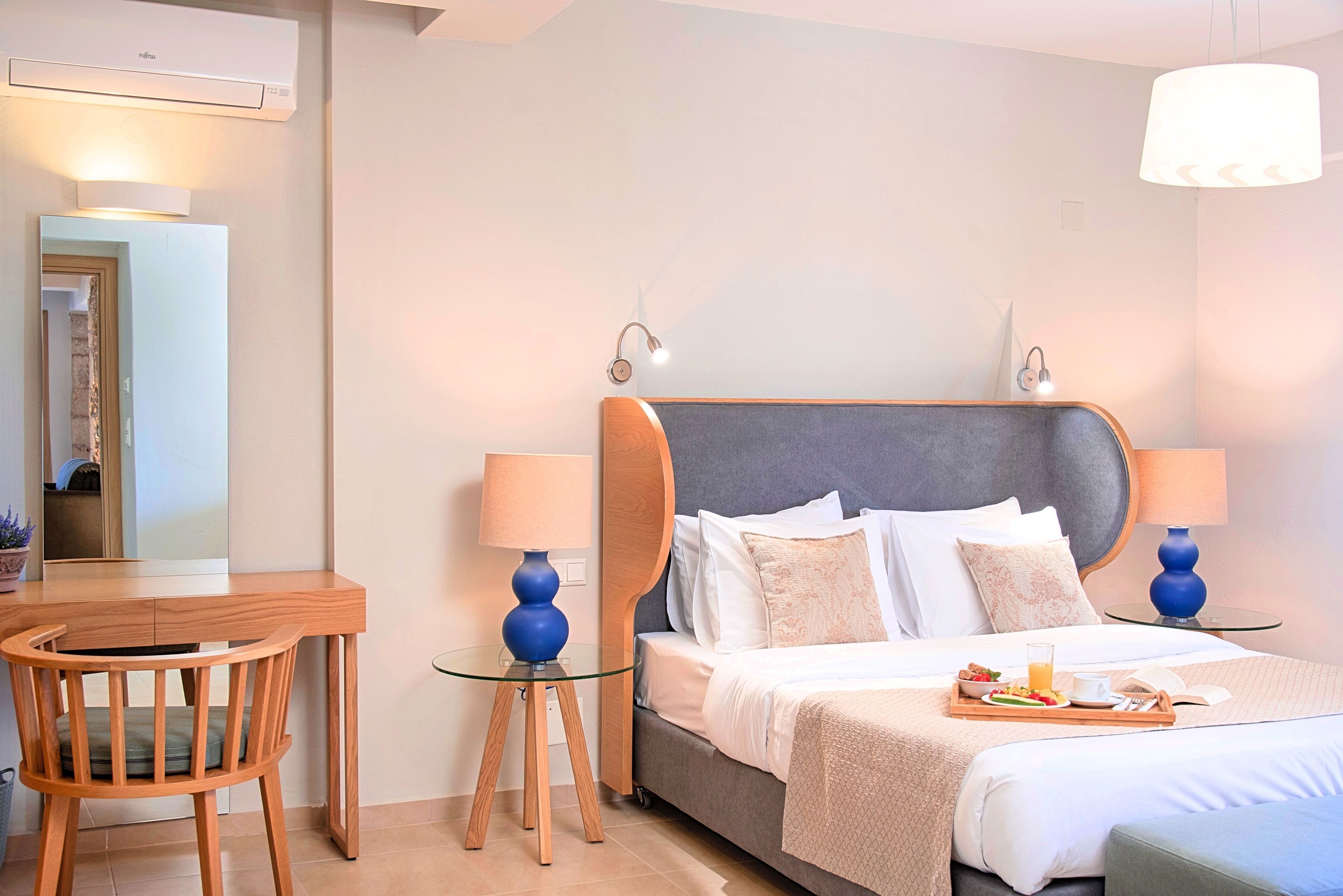 Una habitación de hotel con cama, lámparas de noche, un escritorio y una silla.