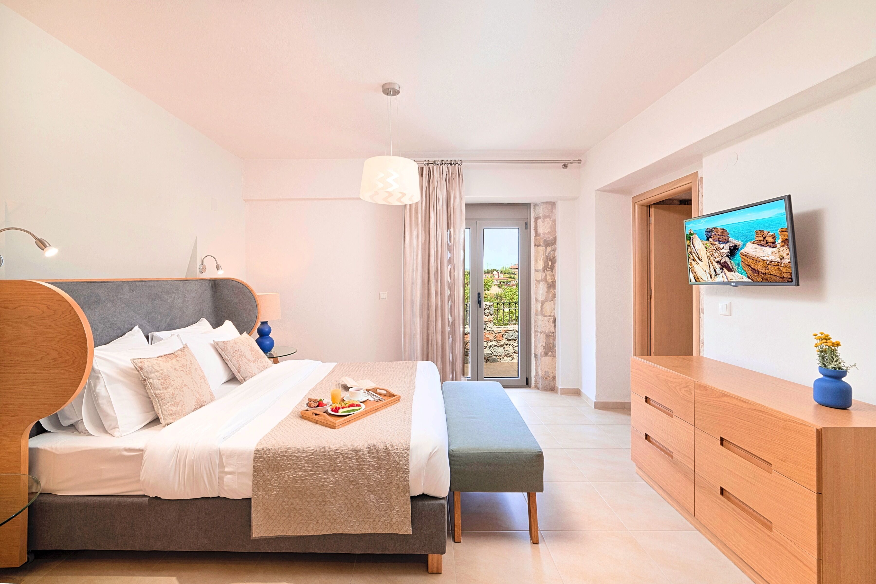 Ein modernes Schlafzimmer mit Bett, Nachttisch und Fernseher an der Wand.