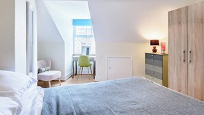 A bedroom with a bed, a desk, and a wardrobe. - 3 bedroom accommodation in Mundesley, near North Walsham (Mundesley, near North Walsham)