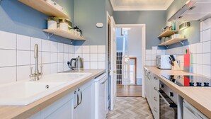 A modern kitchen with white cabinetry, wooden countertops, and a herringbone floor pattern. - 3 bedroom accommodation in Mundesley, near North Walsham (Mundesley, near North Walsham)