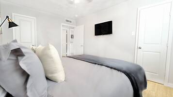 2 habitaciones, escritorio y tabla de planchar con plancha