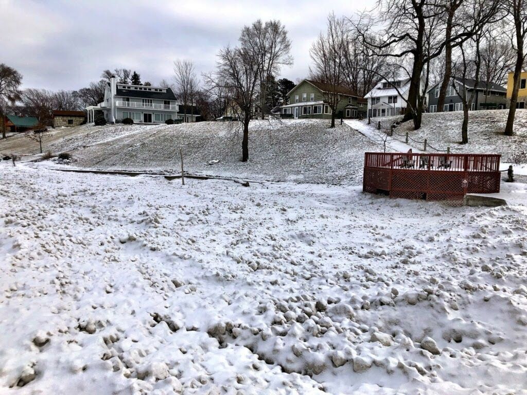 A snow-covered landscape with houses in the background.