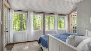 Ett sovrum med en säng, ett fönster och en takfläkt.