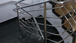 A modern staircase with metal railings and wooden steps. - Aero Inn Hotel (Uberlandia)