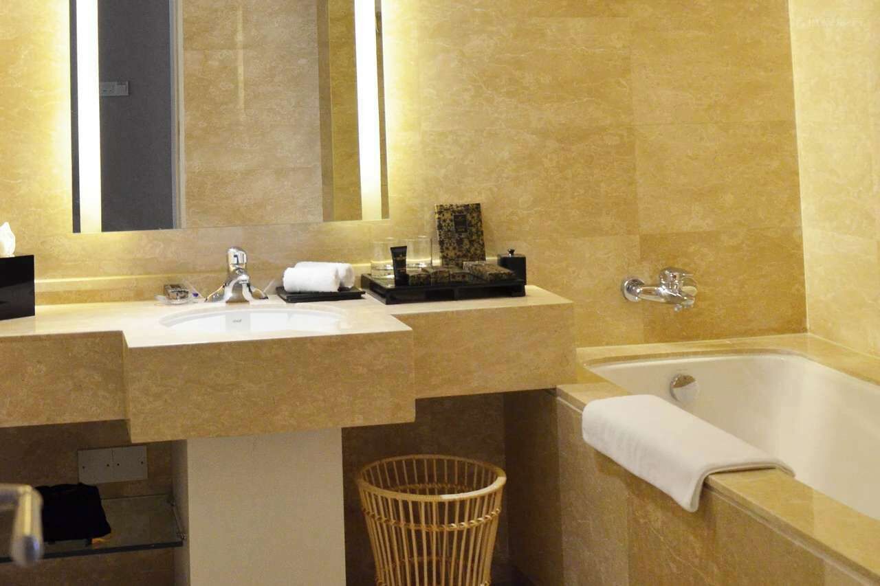A bathroom with a sink, mirror, and bathtub.