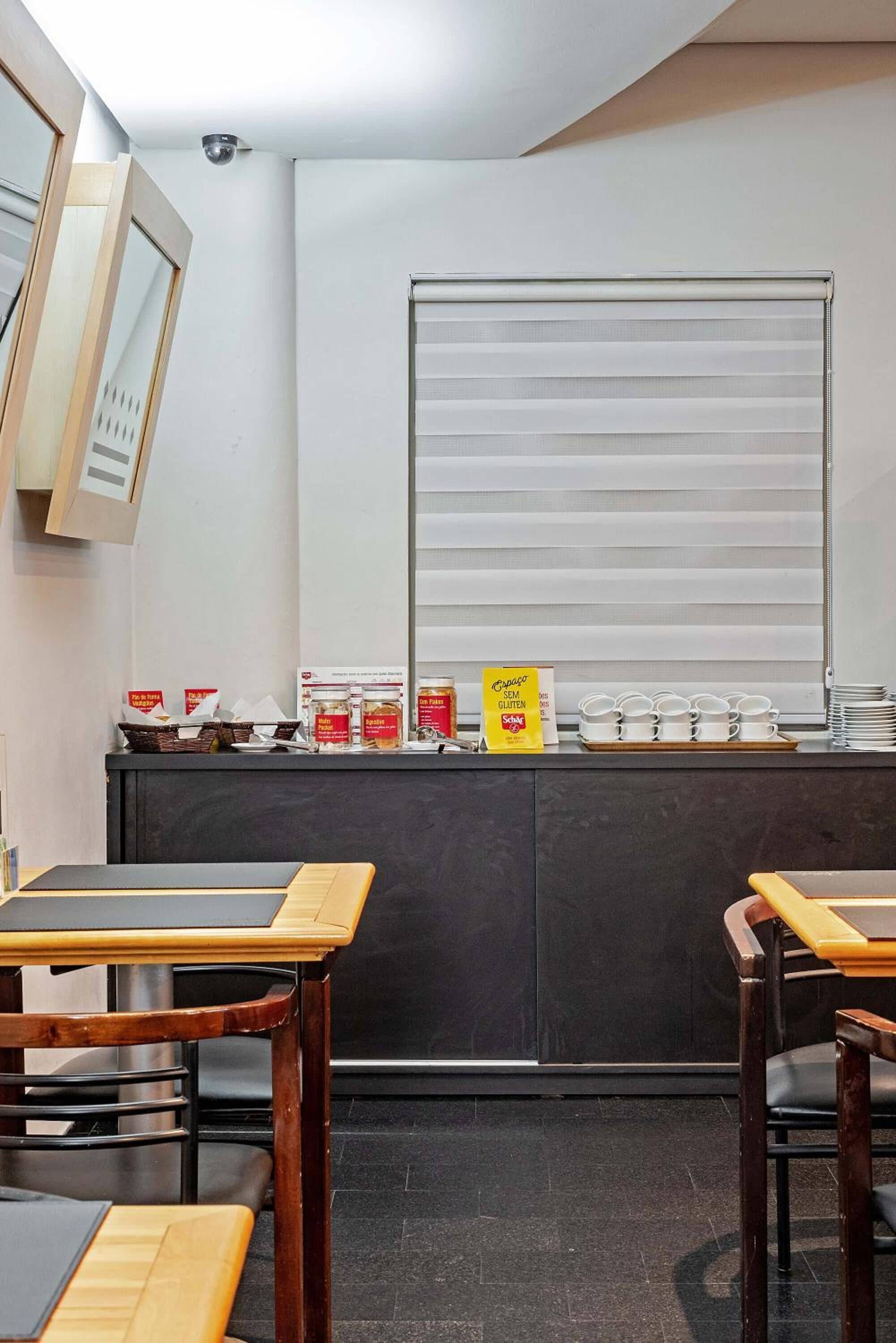 A breakfast bar with a counter, a window with blinds, and a sign indicating gluten-free options.