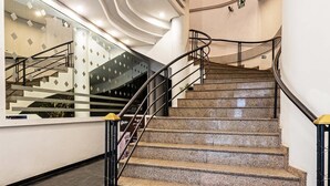 Eine moderne Treppe mit Glastrennwand, die zu einer oberen Etage führt.