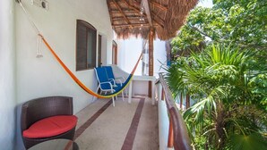 A balcony with a thatched roof, wicker furniture, and a view of lush greenery. - Private Terrace & Hammock Near Mamitas Beach (Playa del Carmen, Q.R.)