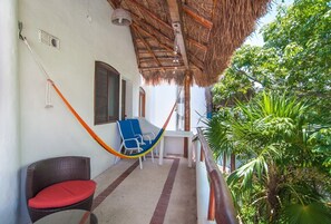 A balcony with a thatched roof, wicker furniture, and a view of lush greenery. - Private Terrace & Hammock Near Mamitas Beach (Playa del Carmen, Q.R.)