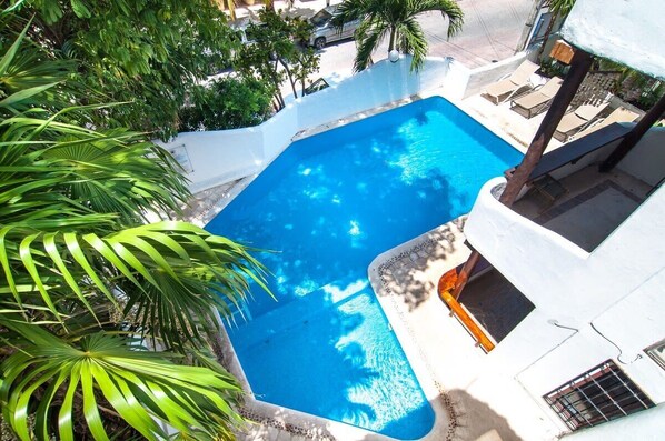 Alberca al aire libre y camastros 