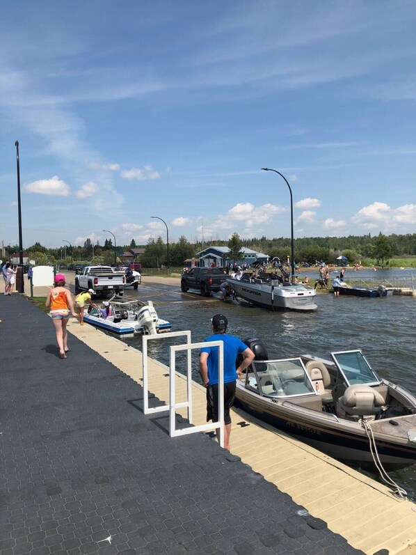 A dock with boats, a clear sky, and a few people walking. - Place to relax from your busy life. (Wabamun)