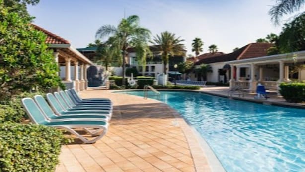A pool area with lounge chairs and a clear blue pool. - Luxury and privacy next to Disney  (Kissimmee)