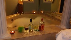 A bathroom with a bathtub, a mirror, and toiletries on the counter. - Luxury and privacy next to Disney  (Kissimmee)