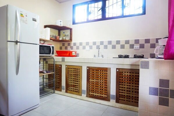 A compact kitchen with a refrigerator, microwave, and sink. - NELLY HOUSE (AP. SANDIA) (SAMARA)