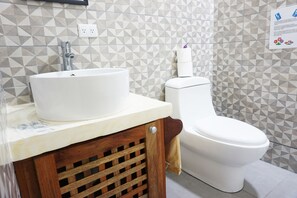 A bathroom with a white sink, toilet, and geometric-patterned tiles. - NELLY HOUSE (AP. SANDIA) (SAMARA)