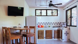 A compact kitchen with a ceiling fan, a TV mounted on the wall, and a refrigerator. - NELLY HOUSE (AP. SANDIA) (SAMARA)