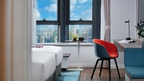 A modern hotel room with a bed, a desk with a chair, a view of the city, and a window with curtains. - Holiday Inn Express Hengyang High-Tech Zone by IHG (Hengyang)