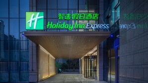 A Holiday Inn Express hotel entrance with a modern design, featuring a prominent green logo and signage. - Holiday Inn Express Hengyang High-Tech Zone by IHG (Hengyang)