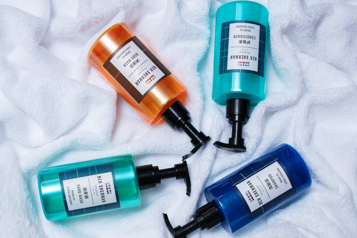 Four bottles of Ben Sherman body wash on a white towel.
