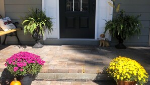 A front door with a 'Gather' sign, two potted plants, and a welcome sign. - The Mulligan House in the heart of Pinehurst, NC. (Pinehurst)